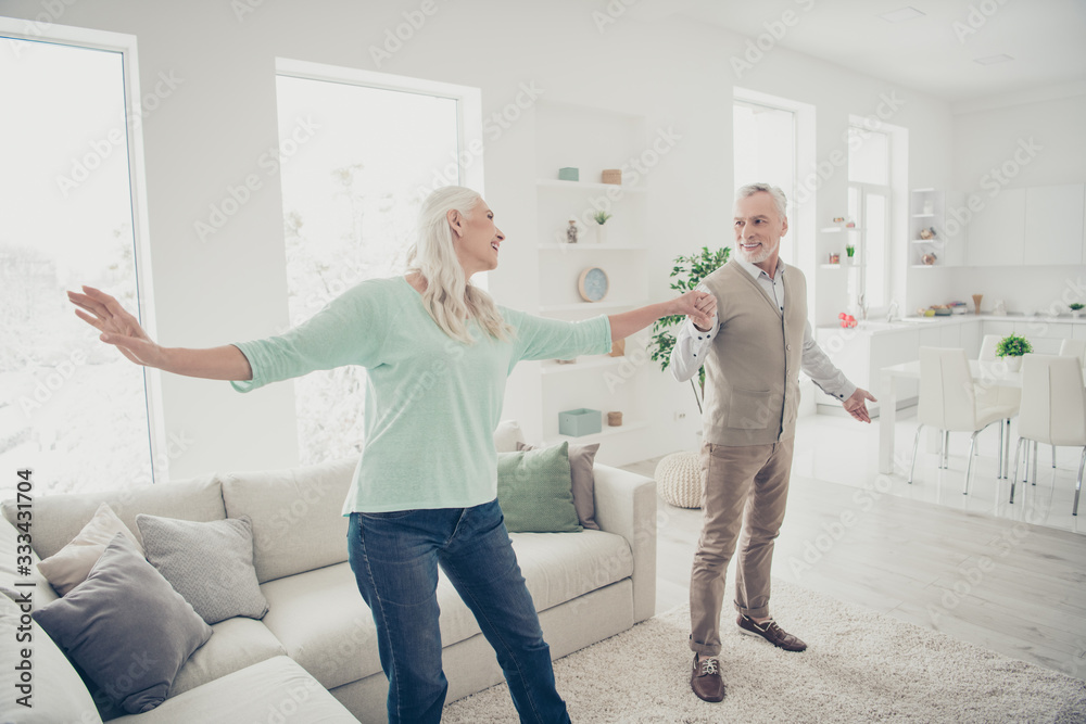 Obraz premium Full size photo of charming passionate couple moving enjoying wearing jeans denim trousers teal brown sweater in light big apartment