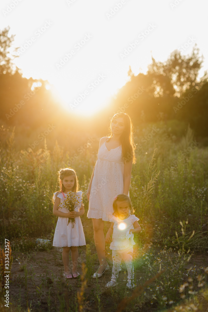 happy family walks in nature. Mom throw their children. Mom and two daughter happy family walks in nature. Mom throw their children. Mom and two daughter