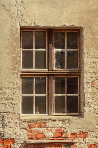 Altes Holzfenster auf verputzter Ziegelsteinwand