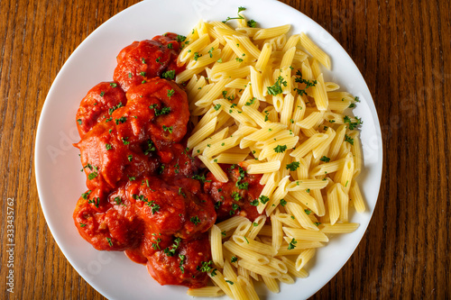 Meatballs in tomato sauce with small penne pasta photo