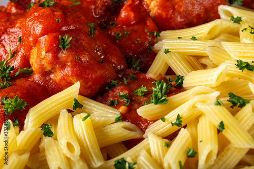 Meatballs in tomato sauce with small penne pasta photo