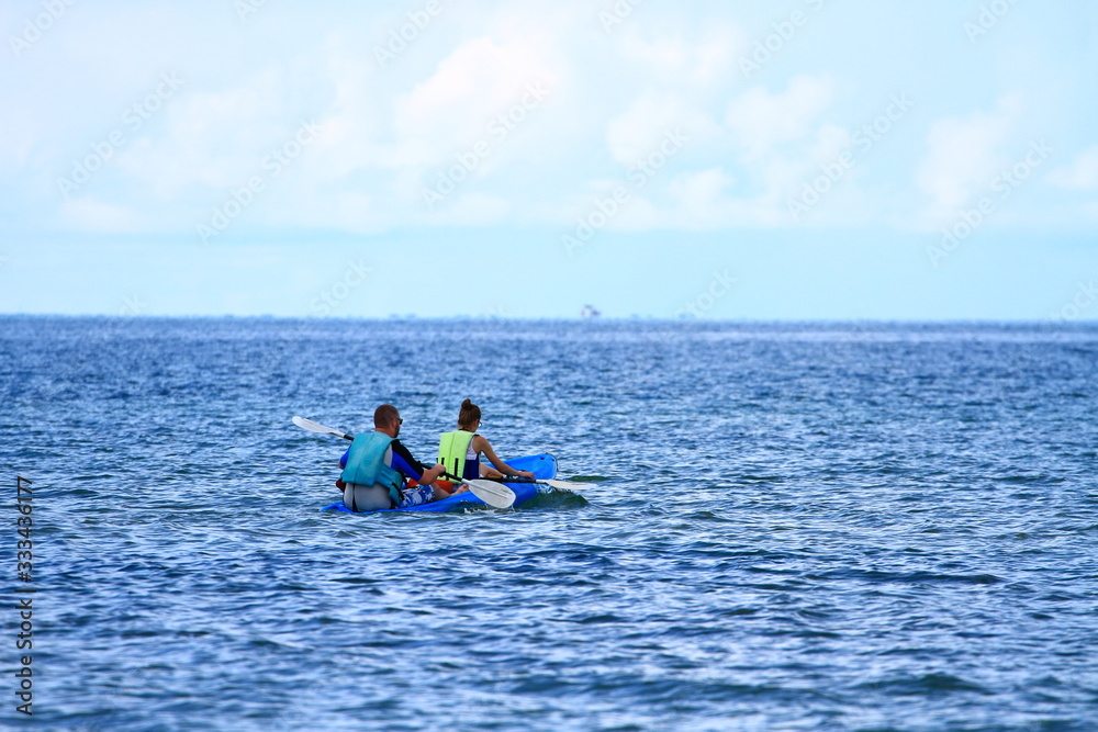 Obraz premium 2 tourists kayaking in the sea for relaxation