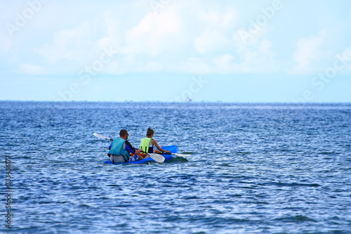 2 tourists kayaking in the sea for relaxation