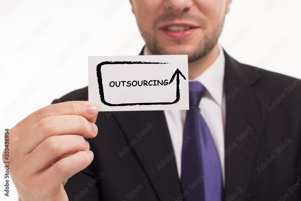 Business, Technology, Internet and network concept. Young businessman working on a virtual screen of the future and sees the inscription: Outsourcing Business, Technology, Internet and network concept. Young businessman working on a virtual screen of the future and sees the inscription: Outsourcing