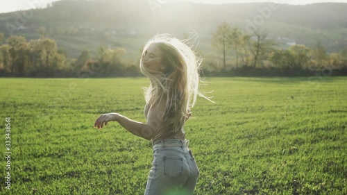 Beautiful young woman jumping look around in landscape grass field meadow nature summer at sunshine hair young spring model pretty relax happiness slow motion