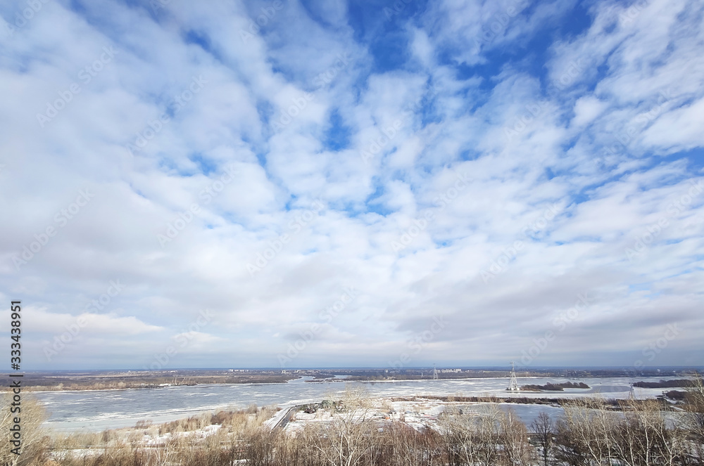 Beautiful early spring river landscape. White clouds over the river and trees on on a sunny day after melting snow. Beautiful early spring river landscape. White clouds over the river and trees on on a sunny day after melting snow.
