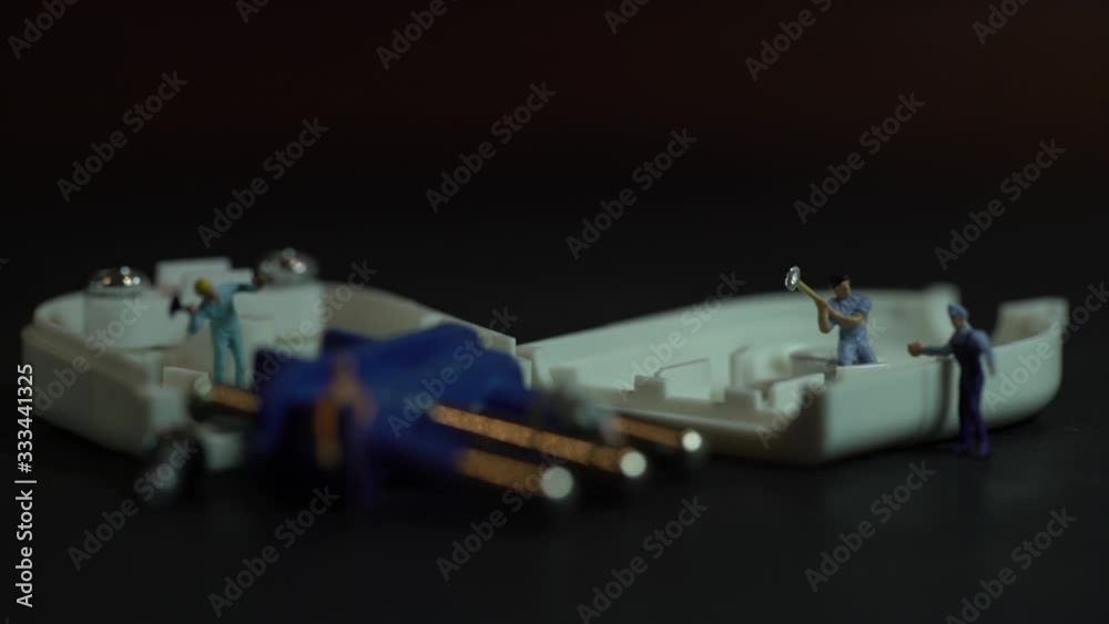 miniature workers work inside an electric plug miniature workers work inside an electric plug