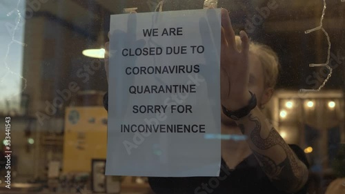 Biohazard concept of living in a new reality of coronavirus epidemic hysteria cafe owner sticks advertisement on quarantine measures to contain virus