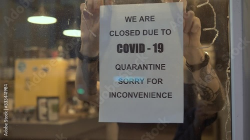 Biohazard concept of living in a new reality of coronavirus epidemic hysteria cafe owner sticks advertisement on quarantine measures to contain virus