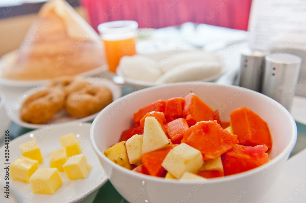 Cut fruits in white bowl on a dinning table. Cut fruits in white bowl on a dinning table.