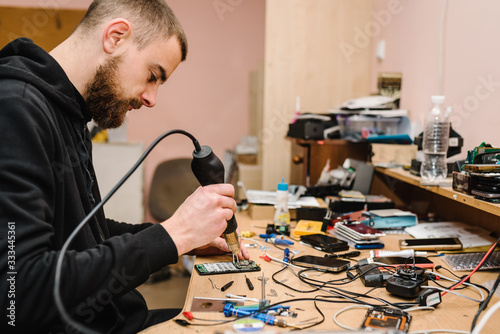Schilderij op canvas The technician repairing the smartphone motherboard in the lab