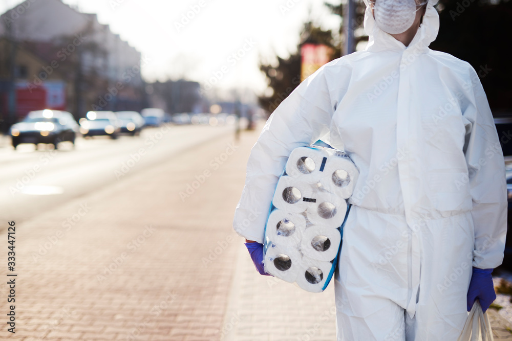 Man carrying reserves of toilet paper Man carrying reserves of toilet paper