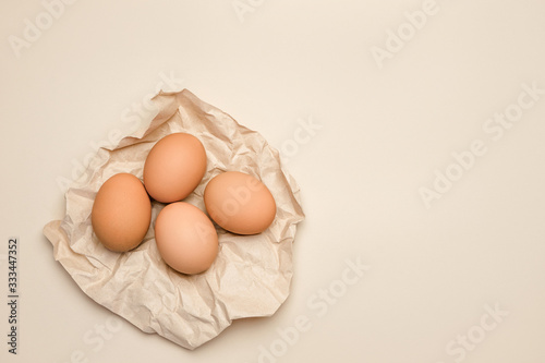 Fotografi Brown fresh hen's eggs on wrinkled craft paper