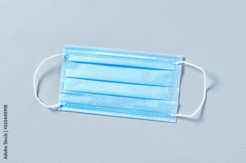 Surgical mask for cover mouth and nose on gray background. Concept of protection, virus epidemic or pandemic, corona virus, covid-19 Surgical mask for cover mouth and nose on gray background. Concept of protection, virus epidemic or pandemic, corona virus, covid-19