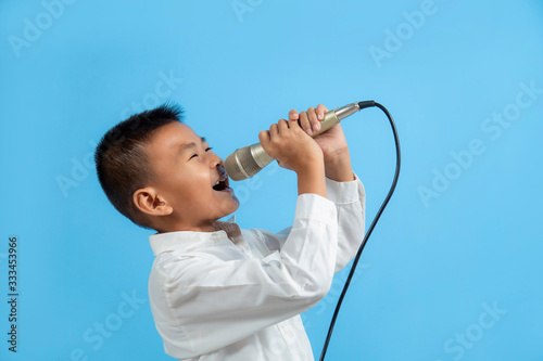Asian boy singing with microphone