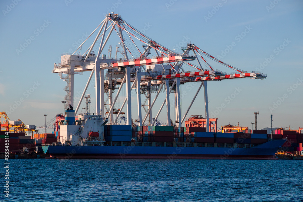 Logistics and container loading by large barges by sea in a harbor full of containers waiting to be transported Logistics and container loading by large barges by sea in a harbor full of containers waiting to be transported