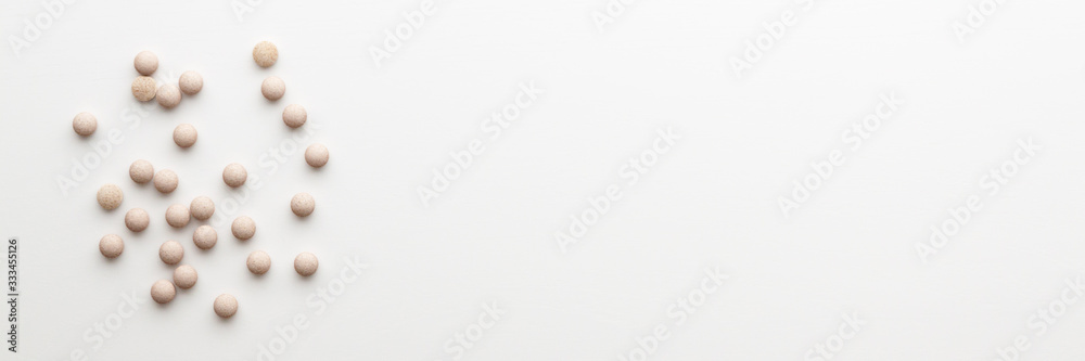 White background with scattered tablets. Bright medical background. Minimal composition. Copy space. Panorama