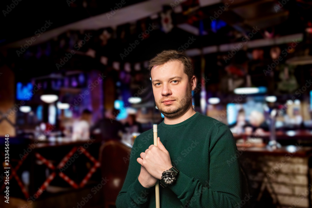 Billiard player portrait. Man plays billiards. Handsome man trying to roll a ball into a pocket. Billiard player portrait. Man plays billiards. Handsome man trying to roll a ball into a pocket.