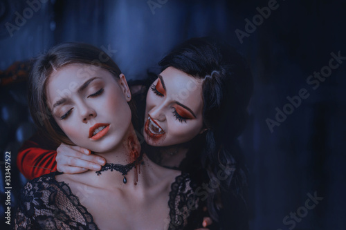 Close Up artwork portrait face sexy vampire woman bites eating drinks young princess. Makeup Drop blood. Bloody wounds bite on neck blonde girl. Horror night halloween. Holiday scary make-up red lips  photo