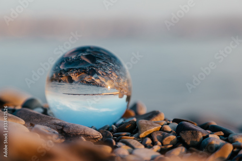  Crystal ball with a reflection of the sea coast. The concept of balance.