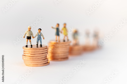 Miniature people: Children standing on top of stacked coins . Image use for background , Life insurance concept, Fund for education