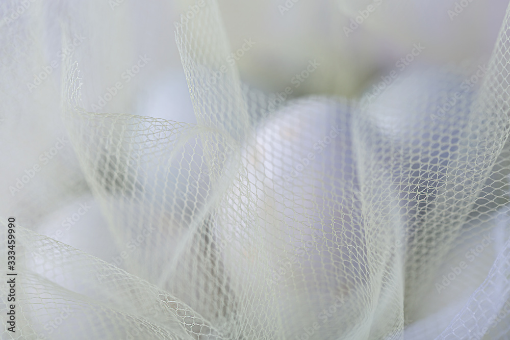 Easter sweet eggs or candies on a white transparent cloth. Decoration for the holiday. Shallow depth of field.