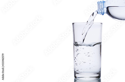 Pouring water into glass isolated on white