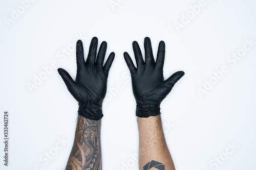 A man hand and gestures in Black rubber glove shows ten sign isolated on white background.