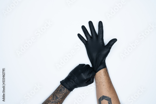 A man holding Variation of Black Latex Glove, Rubber glove manufacturing.