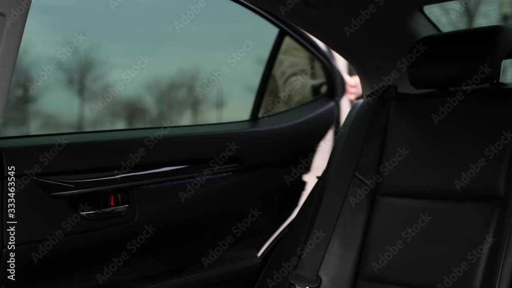 Business woman opens car door and getting out car