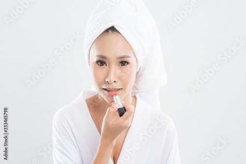 Woman in bathrobe with towel with towel on head.