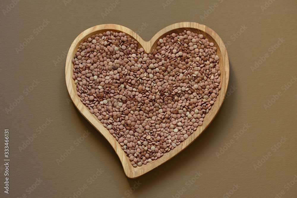 Pile lentil in shape of heart isolated on white background. Top view. Flat lay. Vegetarian and vegan diet.