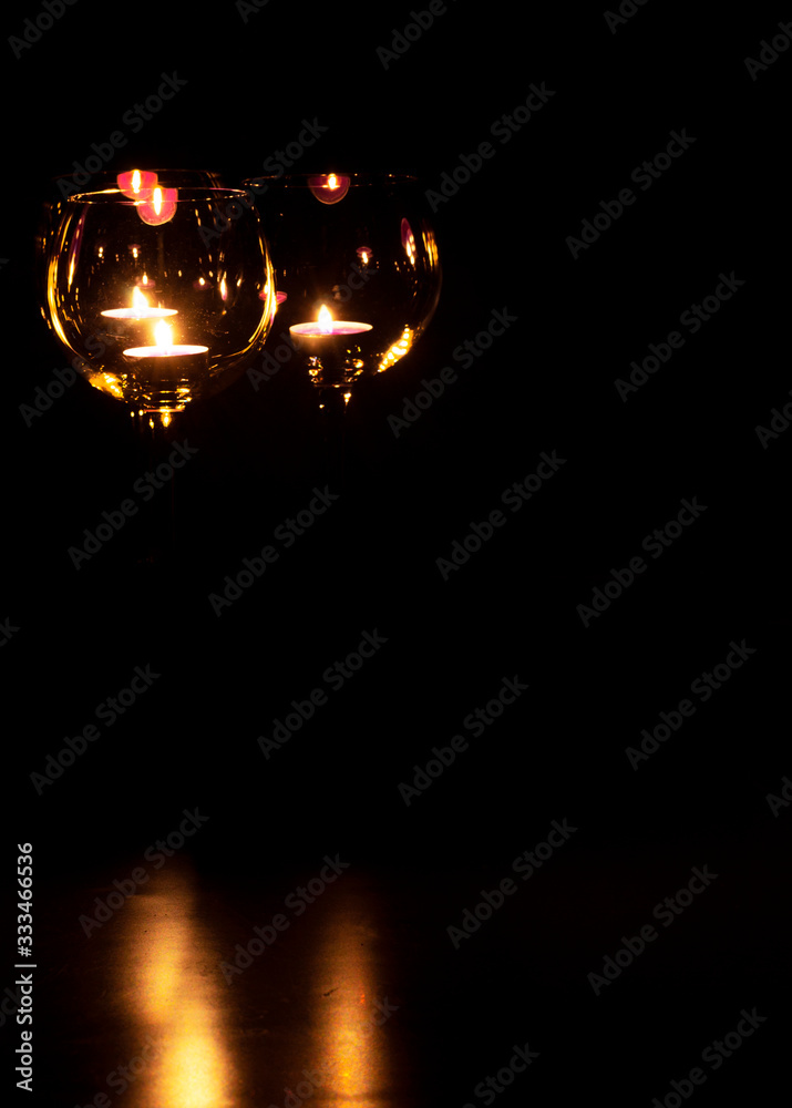 three candels tealights in wine glasses