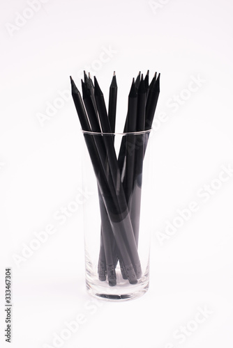 black and wooden pencils in glass isolated on white