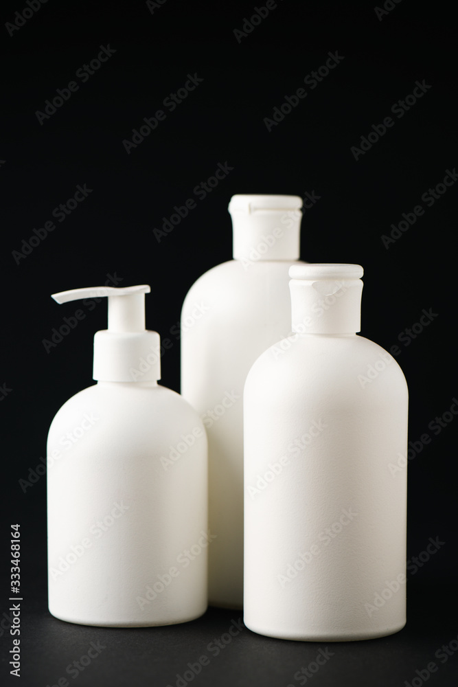 white bottles with cosmetics isolated on black