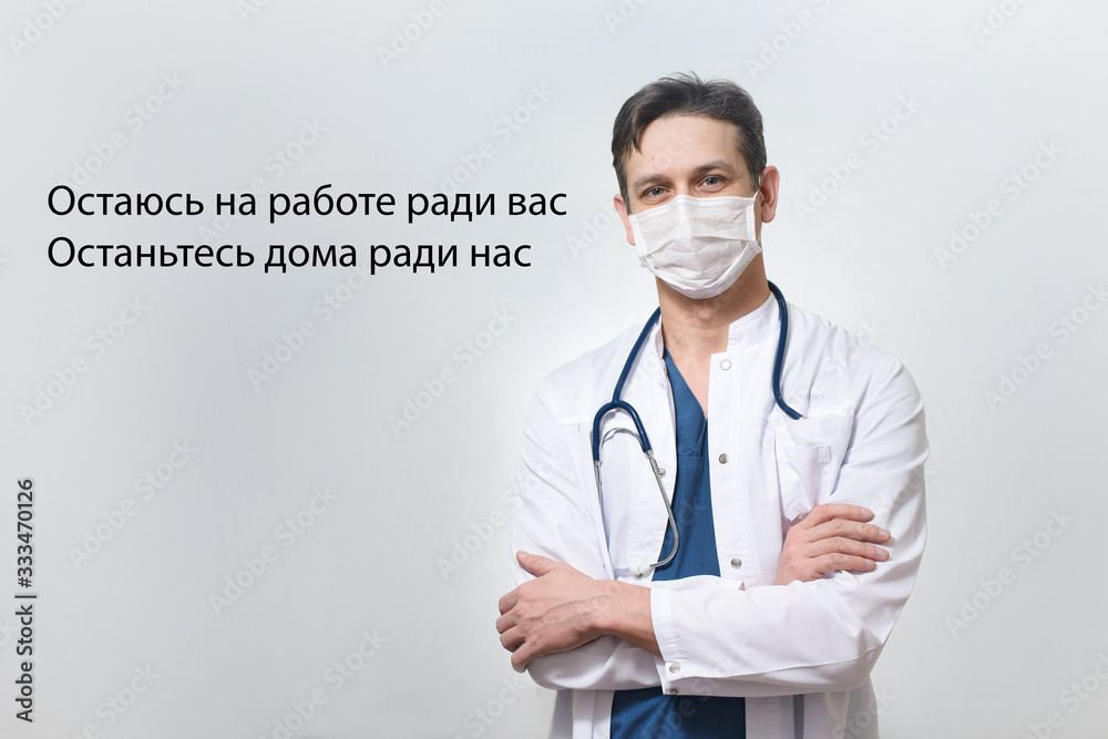 Stay at home caption in russian on the photo of medical doctor in protection mask against Coronavirus or Covid-19 epidemic Stay at home caption in russian on the photo of medical doctor in protection mask against Coronavirus or Covid-19 epidemic