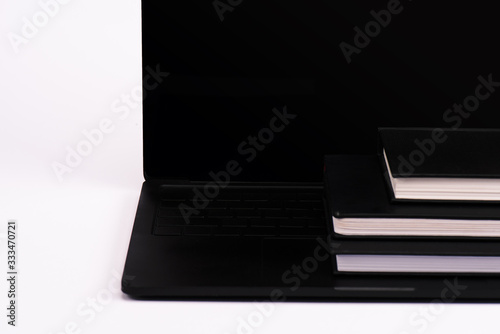 notebooks on modern laptop with blank screen on white © LIGHTFIELD STUDIOS