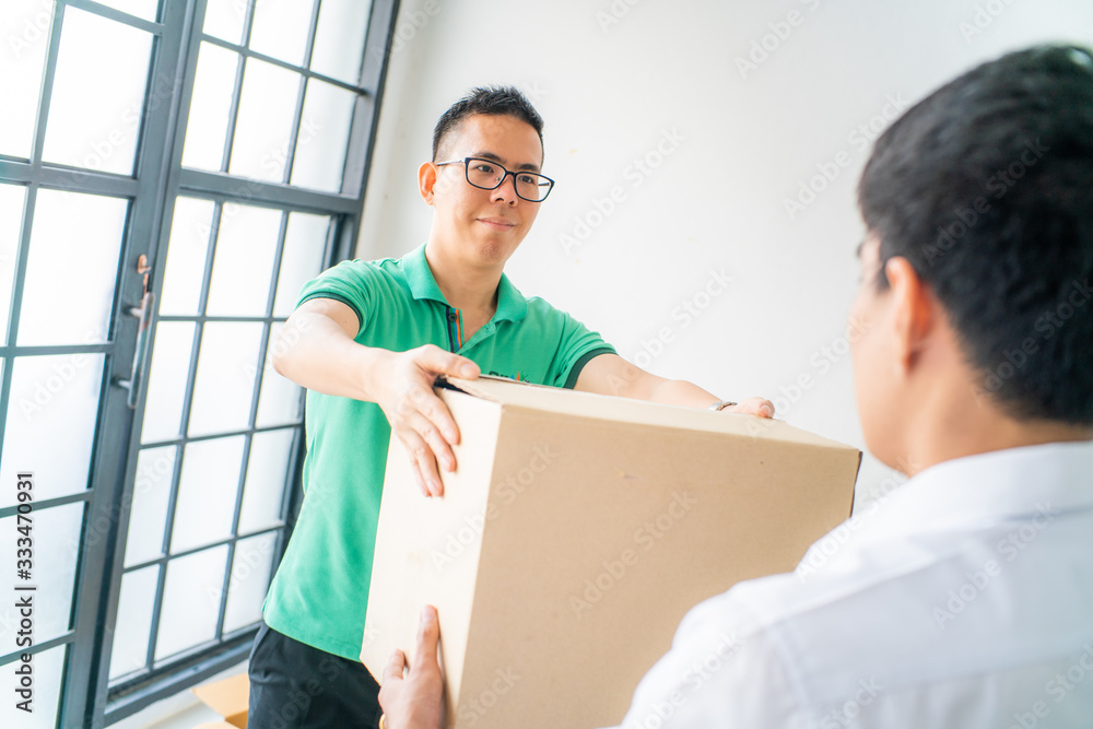 Smart green shirt delivery man delivery of boxes to business office man Smart green shirt delivery man delivery of boxes to business office man