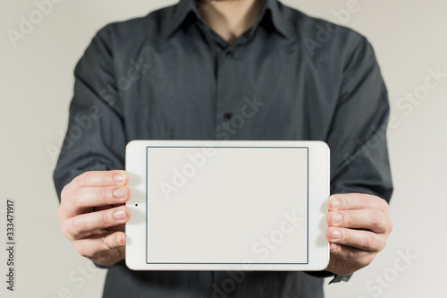 Young man with blank horizontal tablet