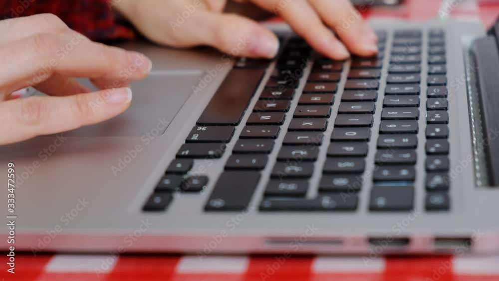 Home office working. Woman working online from home on computer laptop, scrolling and typing, detail of hand on keyboard Home office working. Woman working online from home on computer laptop, scrolling and typing, detail of hand on keyboard