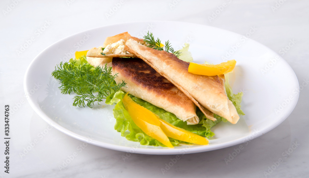 Pita triangles with cottage cheese, herbs, sweet pepper on a white plate