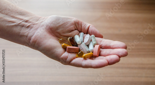Old woman holds in her hand pills - vitamins - dietary supplements - immune system boosts