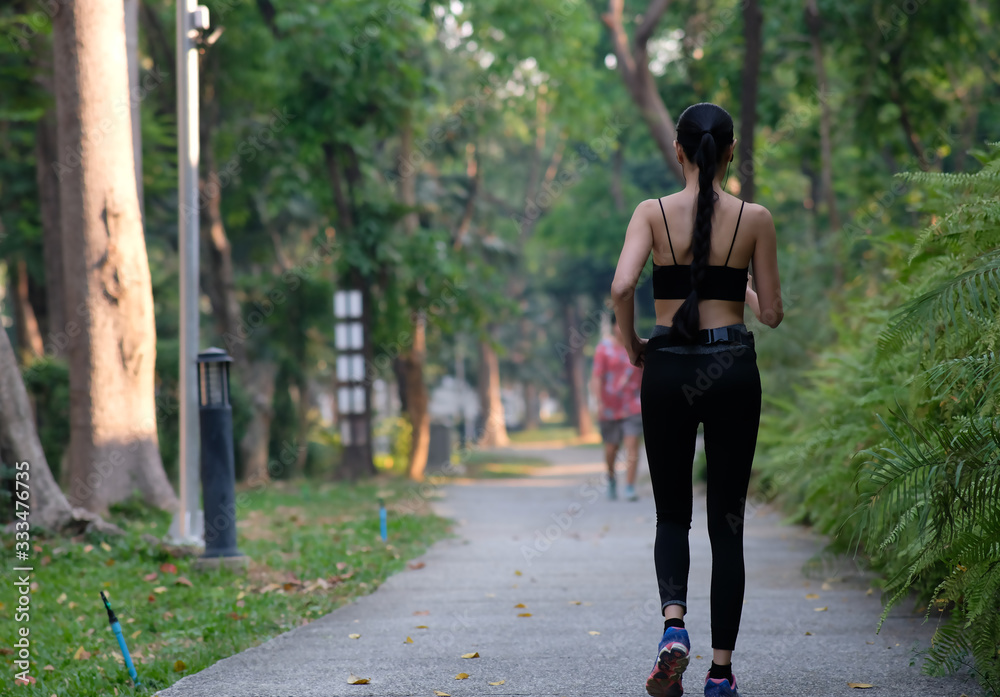 young woman doing exercise in the park and listening music young woman doing exercise in the park and listening music