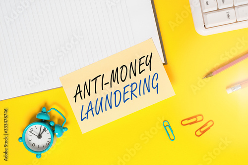 Writing note showing Anti Money Laundering. Business concept for regulations stop generating income through illegal actions Empty orange paper with copy space on the yellow table photo