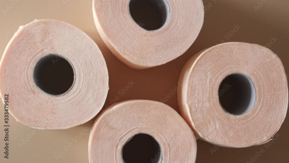 peach beige rolls of toilet paper on a beige background peach beige rolls of toilet paper on a beige background