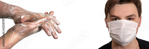 Corona virus. Young guy in a medical protective mask and washing his hands with soap on a white background. Protection against viruses  infections.