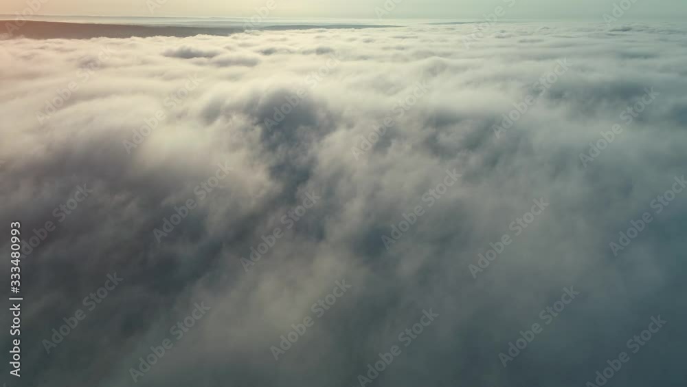 Flight over clouds and fog towards the sun and mountains on the horizon. Flight over clouds and fog towards the sun and mountains on the horizon.