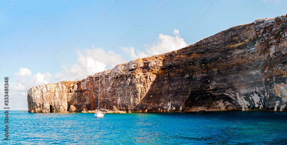 a small yacht in a bay on Comino island, Malta.