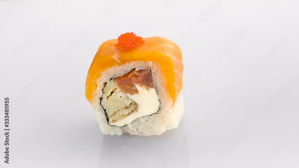 Spinning sushi roll with salmon and caviar isolated on the white background. Spinning sushi roll with salmon and caviar isolated on the white background.