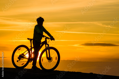 Silhouette of young mountainbike cyclist at sunset, Sweden